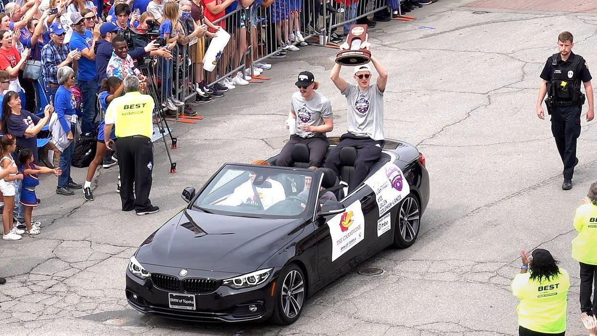 Mitch Lightfoot hoists the trophy as he rides in the parade with Chris Teahan. Thousands of fans gathered along Massachusetts Street in downtown Lawrence Sunday, April 10, 2022, to celebrate the Kansas Jayhawks men’s basketball team, the 2022 NCAA champions.