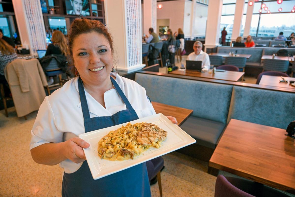 Kate McLaughlin, owner of Brown & Loe, displays the restaurant’s popular Smoked Gouda Mac dish ordered with a grilled chicken breast at the new restaurant at Kansas City International Airport.