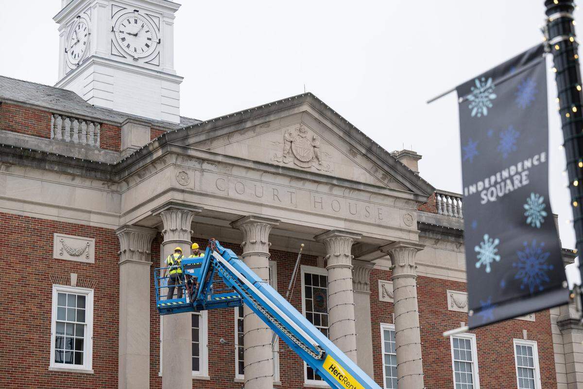 Holiday banners were displayed on light poles Wednesday while electrical workers placed Christmas lights around the pillars of the Historic Truman Courthouse in downtown Independence.
