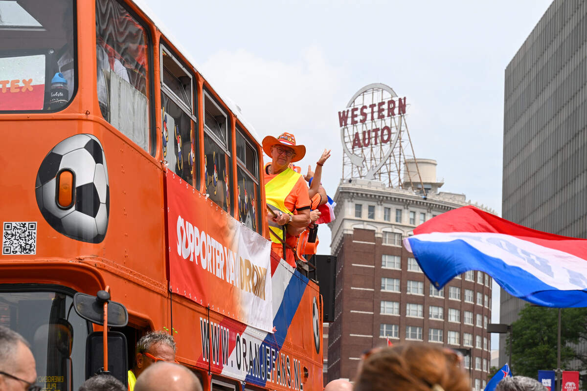 Dutch fans and their iconic ‘Oranje bus’ pass by the Western Auto building as part of the Netherlands Orange Walk from Kansas City’s Power & Light District to FIFA Fan Fest on June 25, 2026.