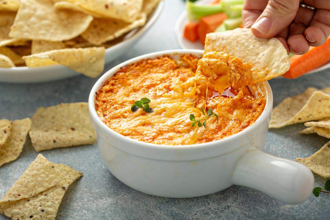 Buffalo chicken dip served with chips and vegetables.