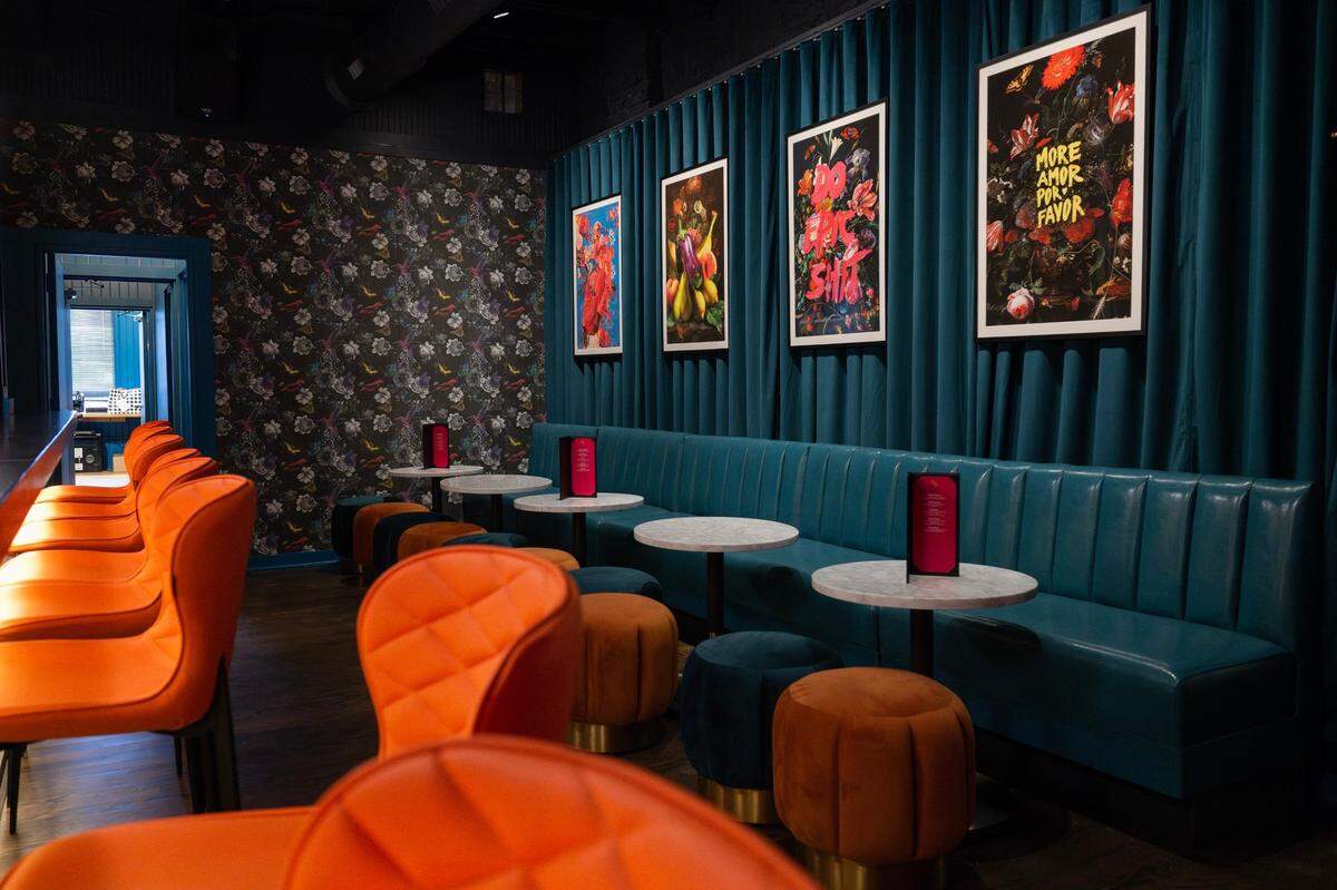 The Q&A Lounge is adorned with velvet curtains, framed photos and patterned wallpaper. It’s meant to be a quieter conversation space.