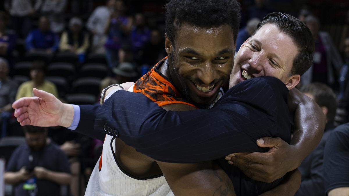 Georgetown College coach Chris Briggs, right, celebrates with Dominique Reid after the Tigers clinched their third NAIA national title Tuesday night at Municipal Auditoruim.