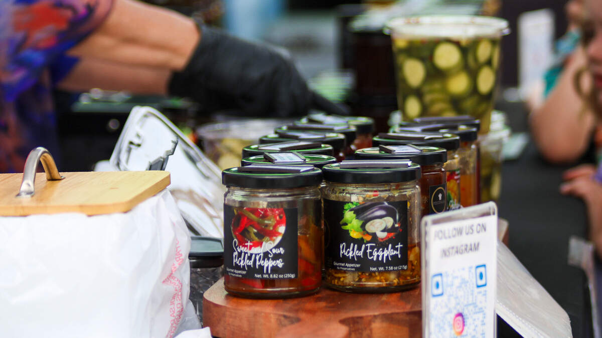A vendor sells canned foods at the Overland Park Farmer’s Market on June 6, 2026.
