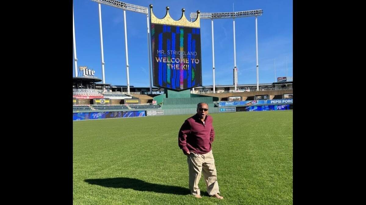 Kevin Strickland stands barefoot in the outfield grass during a visit to the Kansas City Royals’ home field at Kauffman Stadium.