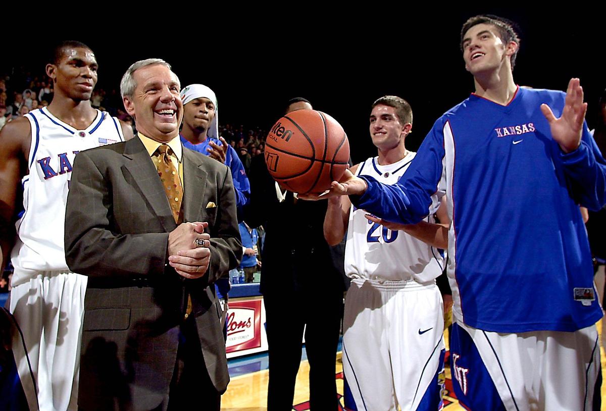 In 2003, KU coach Roy Williams gets ribbed by his players as well as the game ball after posting his 400th win. Senior Nick Collison, right, presented him the game ball.