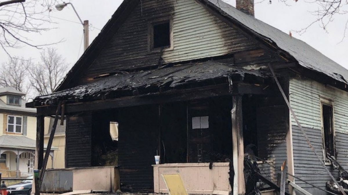 A dangerous home in Kansas City that was later restored into a blue bungalow for sale.