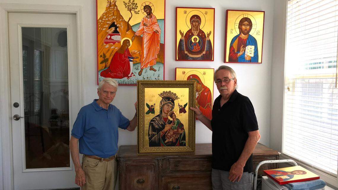 John Gregory, left, presents some of the artwork of artist Tom Dolphens.