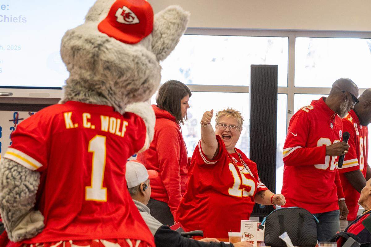 KC Wolf celebrates with the first winner during a round of bingo at the Don Bosco Senior Center on Tuesday, December 30, 2025, in Kansas City. Kansas City Chiefs Ambassadors were in attendance to help ring in the new year.