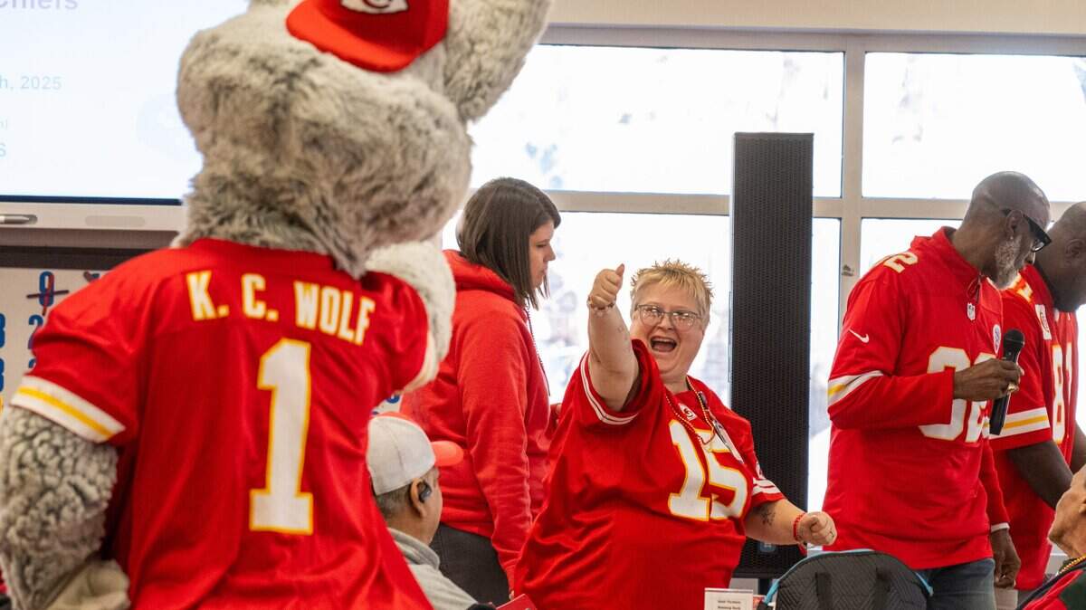 KC Wolf celebrates with the first winner during a round of bingo at the Don Bosco Senior Center on Tuesday, December 30, 2025, in Kansas City. Kansas City Chiefs Ambassadors were in attendance to help ring in the new year.