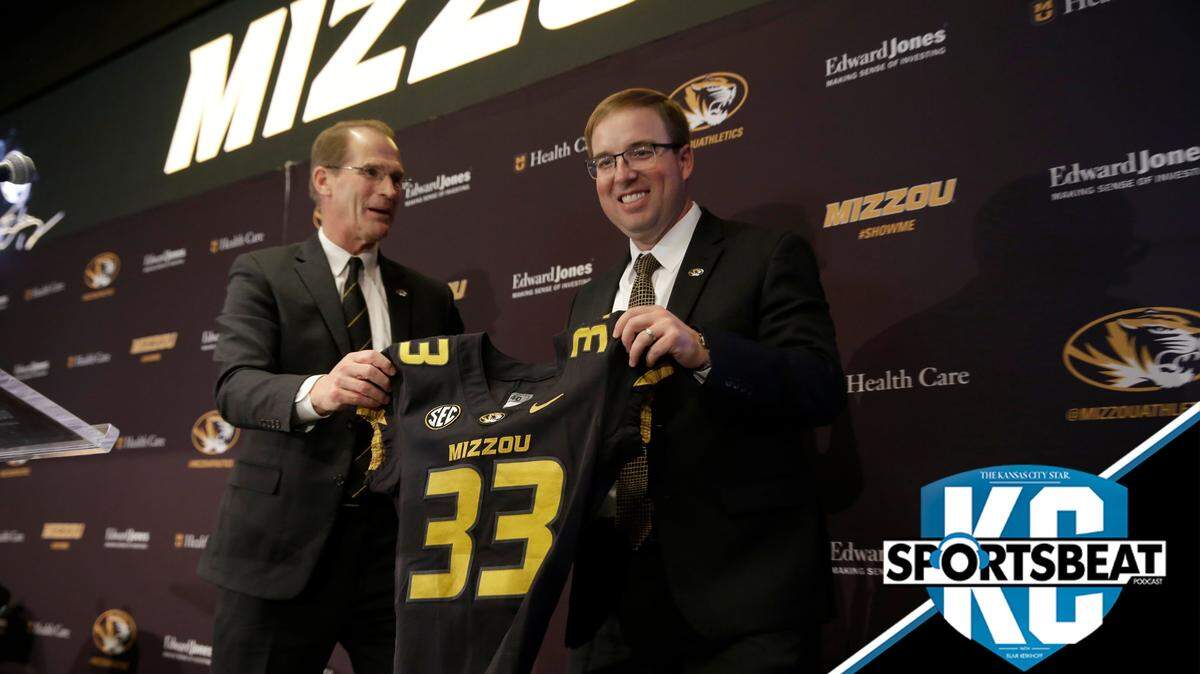 Missouri athletics director Jim Sterk, left, holds up a jersey with Eliah Drinkwitz after introducing Drinkwitz as the new head football coach at the University of Missouri Tuesday, Dec. 10, 2019, in Columbia, Mo. Drinkwitz becomes the 33rd head football coach at Missouri after coaching the 2019 season at Appalachian State. (AP Photo/Jeff Roberson)