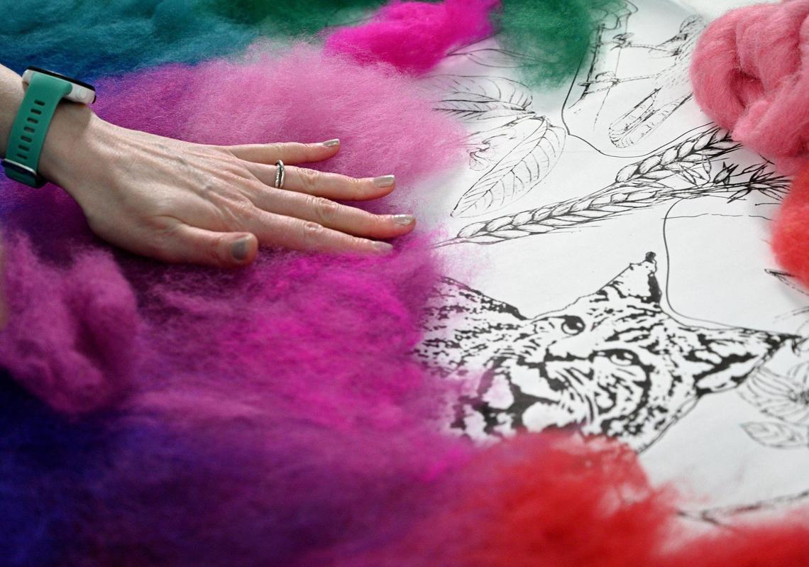 Rachelle Gardner-Roe lays down hand-dyed wool on a drawing to create a smooth color gradient for her “Flyover Country: The Wild Side.”’ It is a triptych made of wool from Shetland sheep and alpaca raised on her family’s farm and hand-dyed by her mother.