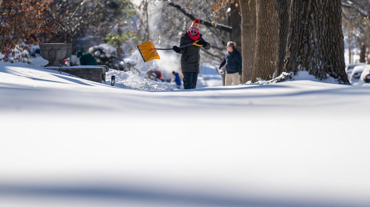 Residents clear snow from the sidewalk on Monday, Jan. 6, 2025, in Kansas City.