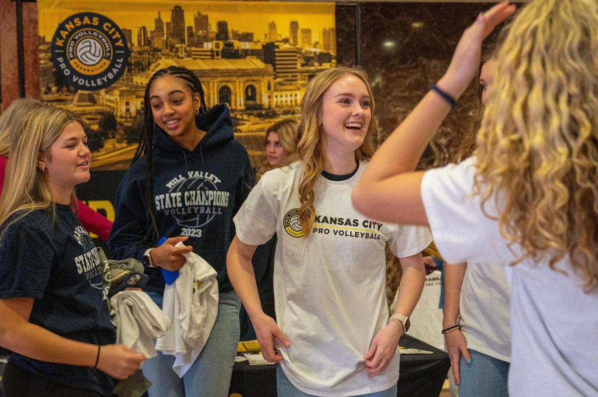 Addison Bailey, center, tries on a T-shirt from the Kansas City Pro Volleyball booth during a luncheon for the Win for KC Women’s Sports Awards at the Municipal Auditorium on Tuesday, Jan. 30, 2024, in Kansas City.