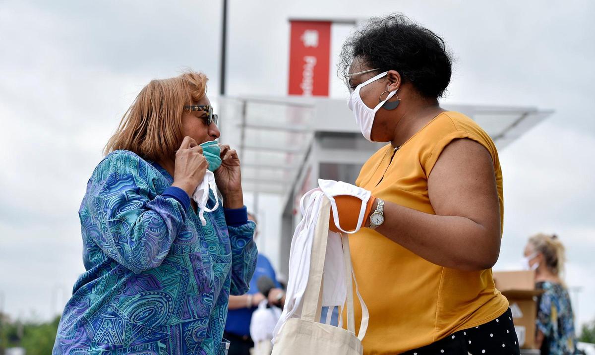 Melissa Robinson, 3rd District councilwoman in Kansas City, right, helped distribute masks at a bus stop at 31st Street and Prospect Avenue in late June. 