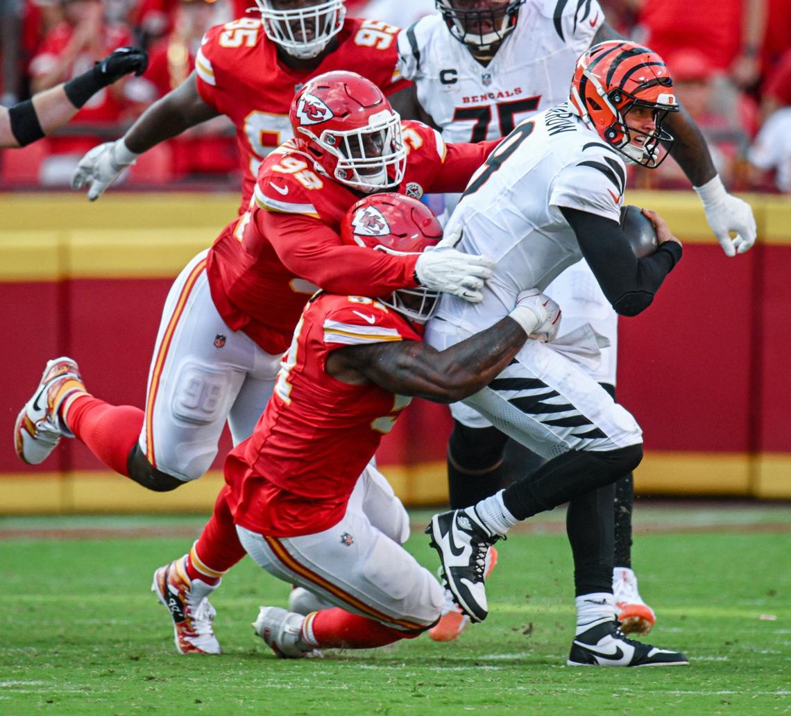 Kansas City Chiefs defensive tackle Tershawn Wharton (98) and defensive end Mike Danna (51) tackle Cincinnati Bengals quarterback Joe Burrow (9) who fumbled on the play in the second half. Sunday, Sept. 15, 2024, at GEHA Field at Arrowhead Stadium. The ball was picked up by Kansas City Chiefs safety Chamarri Conner (27) who ran it in for a touchdown.