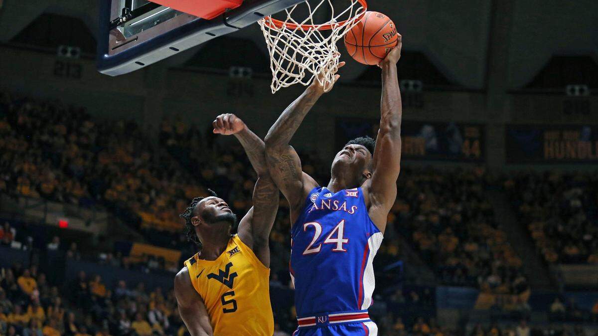 Kansas forward K.J. Adams Jr. (24) is defended by West Virginia guard Joe Toussaint (5) during the first half in Morgantown, W.Va., Saturday, Jan. 7, 2023.
