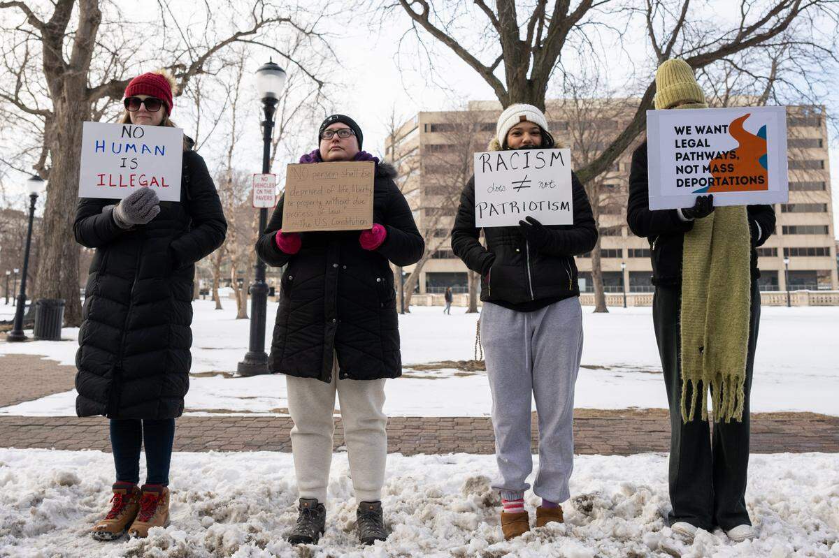 A group of women hold signs at a silent anti-ICE protest near Washington Park on Tuesday, January 27, 2026, in Kansas City.