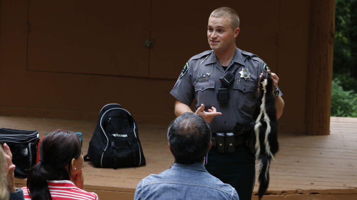At Ernie Miller Park and Nature Center’s Amphitheater on Friday evening, Seth Salmans, Johnson County Parks and Recreation Park Police Officer presented an educational program fun, educational program, “The Good, The Bad, and The Smelly” for an audience of more than 100 children and adults.