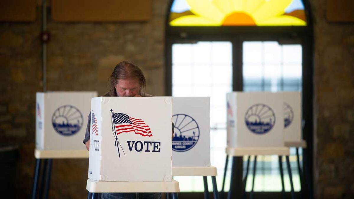 Aug 2, 2022; Topeka, KS, USA; A Shawnee County voter examines his choices in the primary elections as he fills out a paper ballot Tuesday morning inside Heritage Hall in Topeka.  Mandatory Credit: Evert Nelson-USA TODAY NETWORK