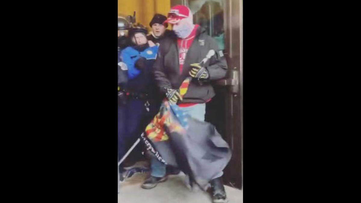 Joseph Kerry Hicks is seen gripping a flag inside the Capitol on Jan. 6, 2021.