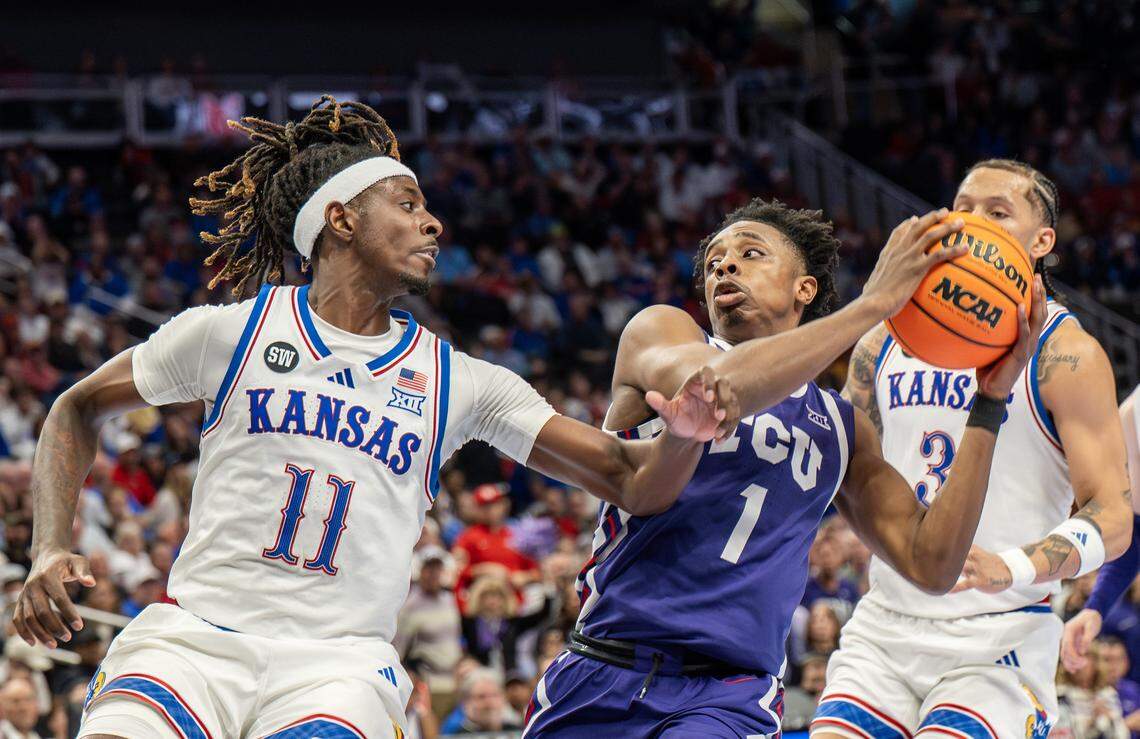 Texas Christian University Horned Frogs guard Jayden Pierre (1) shields the ball from Kansas Jayhawks guard Jamari McDowell (11) during the first half of a Big 12 Men's Basketball Tournament game at T-Mobile Center on Thursday, March 12, 2026, in Kansas City.