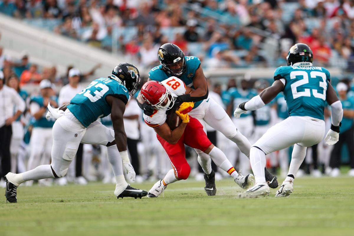 Kansas City Chiefs tight end Travis Kelce (87) is tackled by Jacksonville Jaguars defensive end Trevis Gipson (50) in the first quarter during preseason at EverBank Stadium.