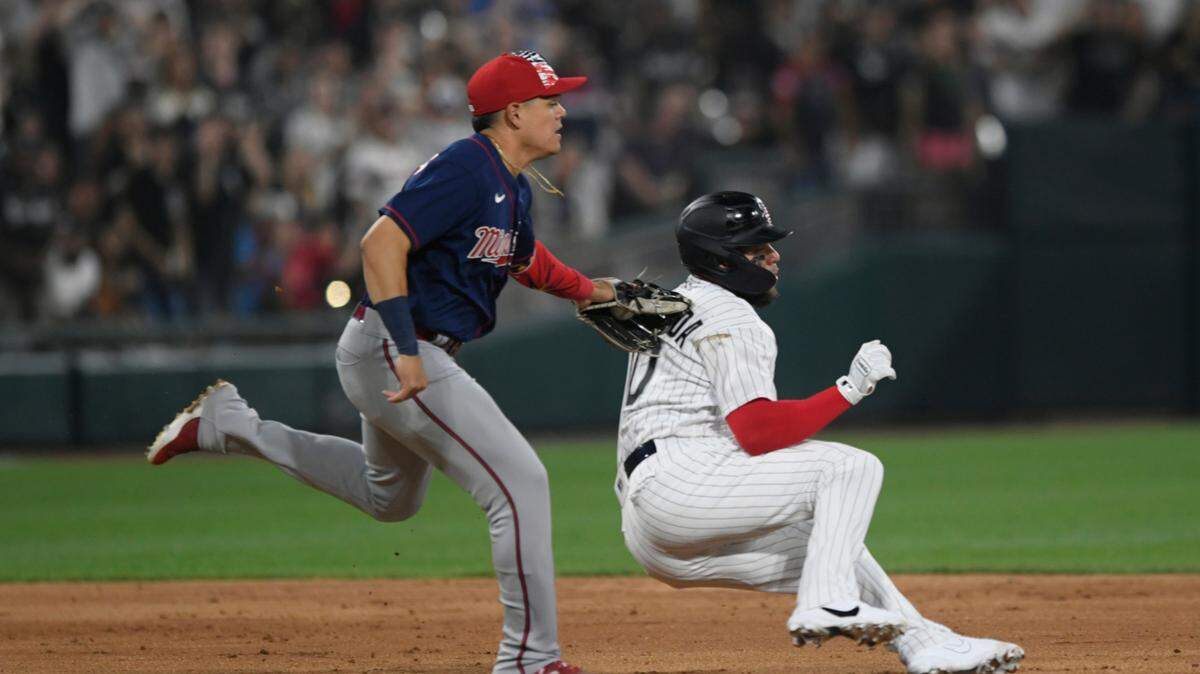 Chicago White Sox’s Yoan Moncada right, is caught during a rundown by Minnesota Twins third baseman Gio Urshela left, during the seventh inning of a baseball game Monday, July 4, 2022, in Chicago. (AP Photo/Paul Beaty)