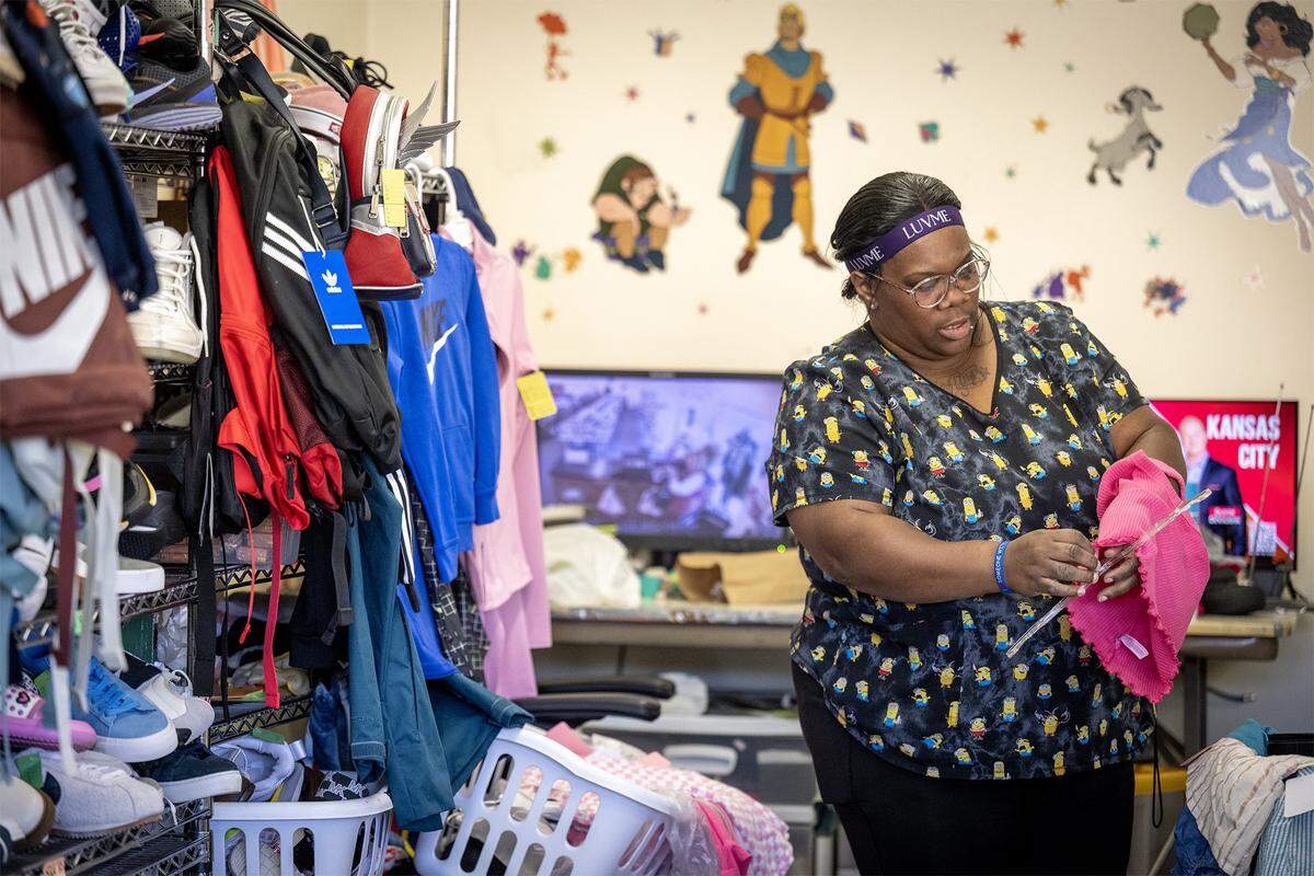 Shawntae Simmons, an employee at Annie's, a children's resale store, 841 W 39th St., hung up children's clothing on Tuesday, October 21, 2025, in Kansas City. The shop is being forced to close as the building is going up for sale.