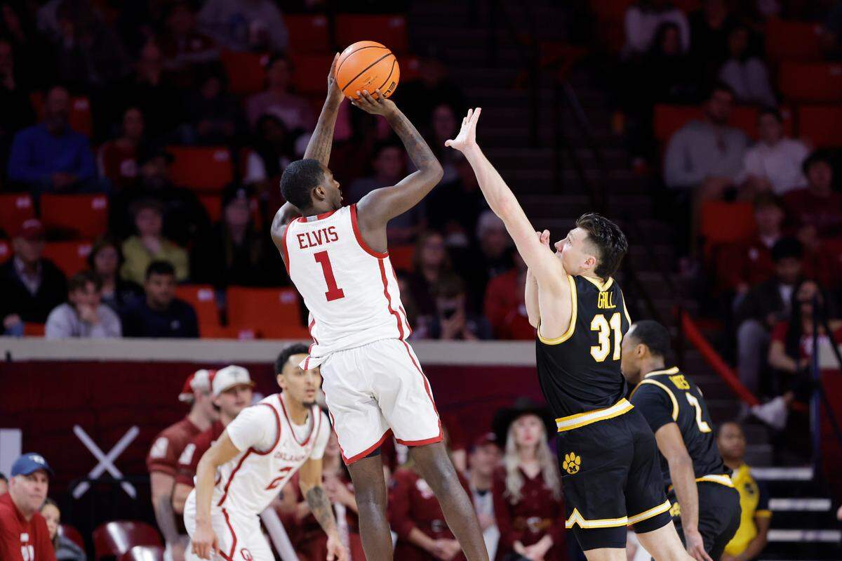 Oklahoma Sooners guard Kobe Elvis, left, shoots a 3-pointer over the outstretched arm of Missouri Tigers guard Caleb Grill during an SEC men’s basketball game at the Lloyd Noble Center on Wednesday, March 5, 2025 in Norman, Okla.