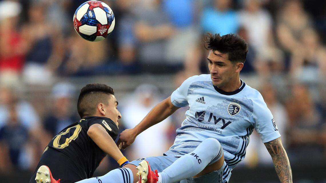 Los Angeles FC midfielder Eduard Atuesta, left, heads the ball away from Sporting Kansas City midfielder Felipe Gutierrez during the first half of Wednesday’s game in Kansas City, Kan.