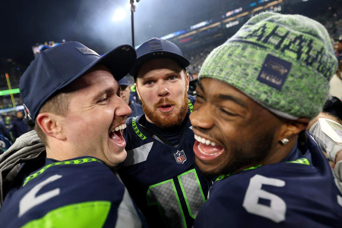 Drew Lock #2, Sam Darnold #14 and Jalen Milroe #6 of the Seattle Seahawks celebrate after defeating the Los Angeles Rams 31-27 in the NFC Championship game at Lumen Field on January 25, 2026 in Seattle, Washington.