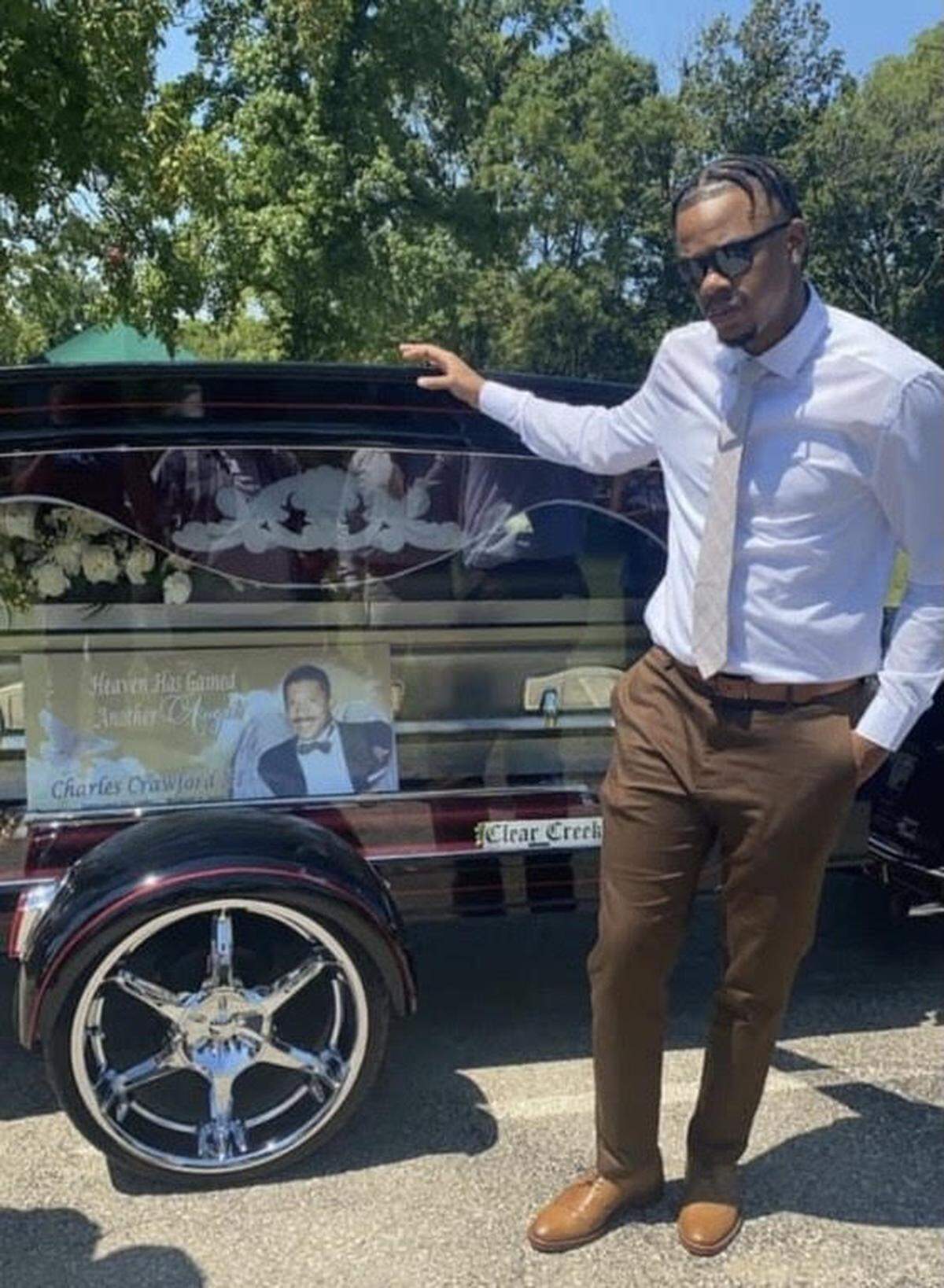 Cardell Crawford, 24, stood in front of the casket of his father, who died of COVID-19 last year.