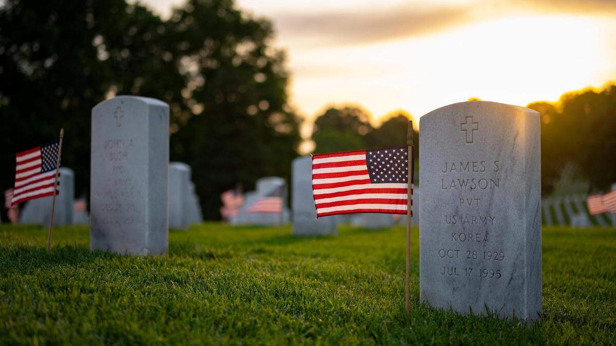 American flags dot the graves at The Leavenworth National Cemetery as the sun rises on Sunday, May 29, 2022, in Leavenworth, Kansas, the day before Memorial Day. Weather this year for the holiday weekend is expected to be ideal for outdoor activities.