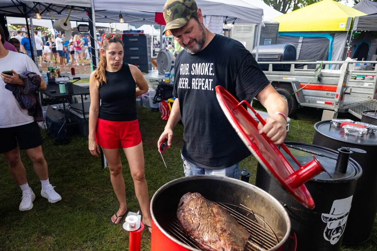 Husband and wife and co-cooks of Aporkcalypse Lauren, left, and Jared Cox check their brisket at The Great Lenexa BBQ Battle on Friday, June 26, 2026. The first time team uses the “hot and fast method” to cook their brisket rather than low and slow. “This way we also get to sleep tonight,” quoted Jared Cox.