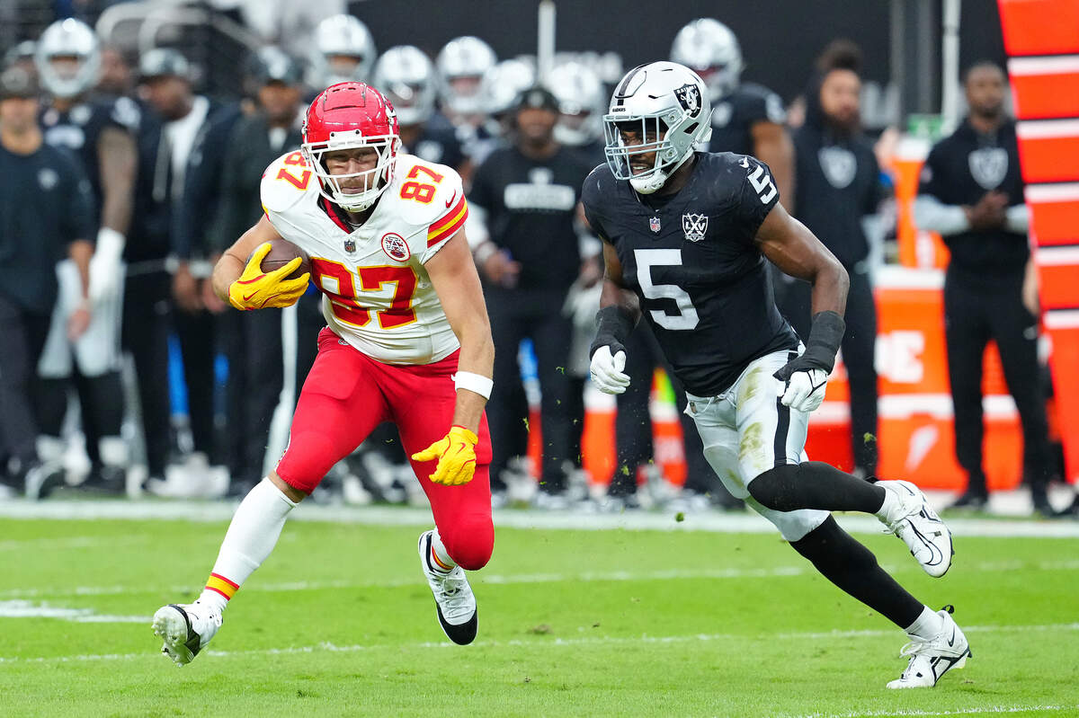 Kansas City Chiefs tight end Travis Kelce (87) looks to evade the tackle of Las Vegas Raiders linebacker Divine Deablo (5) during the first quarter at Allegiant Stadium.