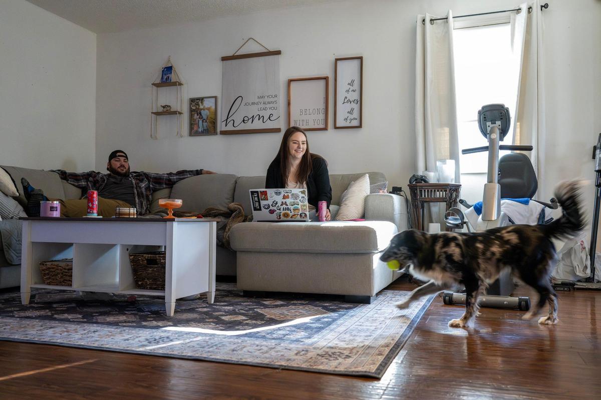 Carleigh and Greg Crossno play fetch with their dog, Piper, in the living room of their home on Sunday, March 9, 2025, in Blue Springs. The Crossno family has struggled to find a home amid rising prices and competition from out-of-state investors in the Kansas City area.