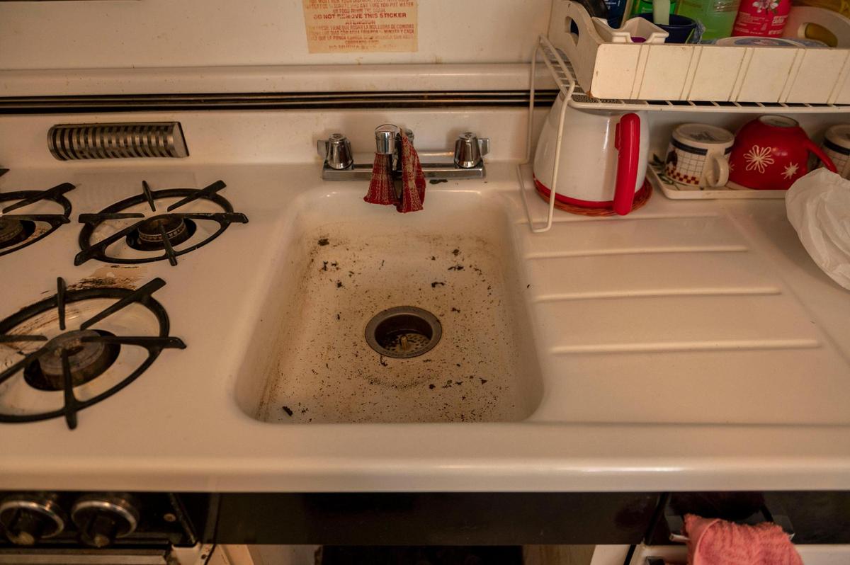 A resident at Cross-lines Retirement Center shows the mold and rust of the sink at her apartment.