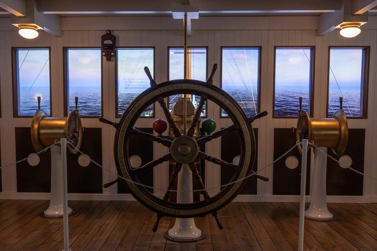 A replica of the Titanic's ship wheel is displayed against a digital backdrop of the open ocean at the Titanic: An Immersive Voyage exhibit at Union Station on Thursday, Nov. 6, 2025, in Kansas City.