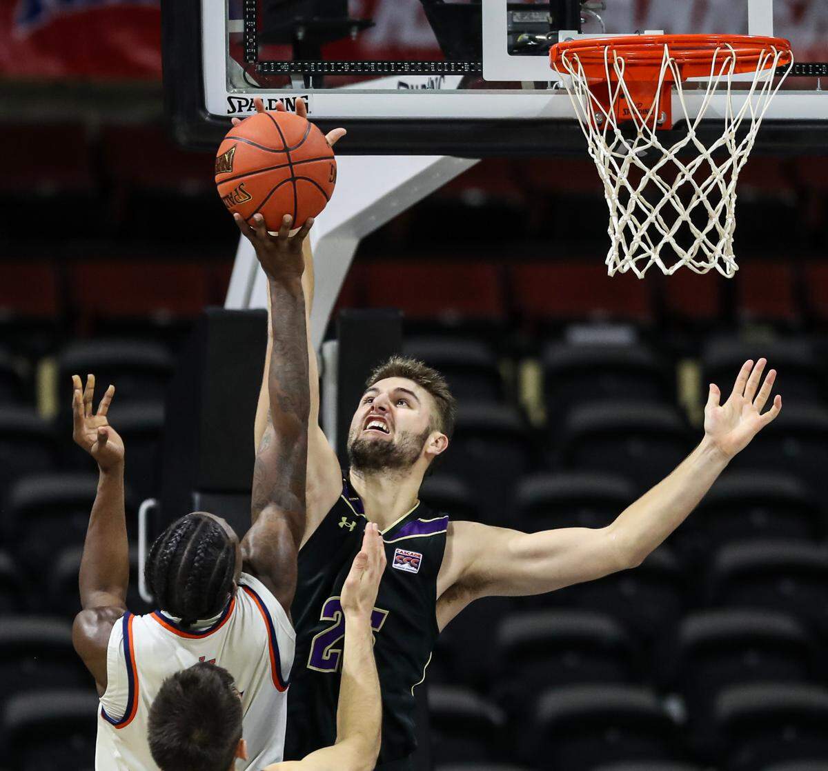 College of Idaho’s Paul Wilson blocks the shot from Cortez Mosley of Langston in the NAIA semifinals on Monday night at Municipal Auditorium. The Yotes, however, could not defend their title and lost to the Langston Lions, 58-52.