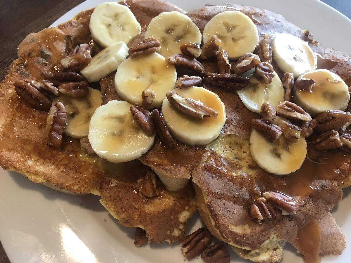 Caleb’s Caramel Nut French Toast with warm caramel sauce, fresh banana slices and pecans.