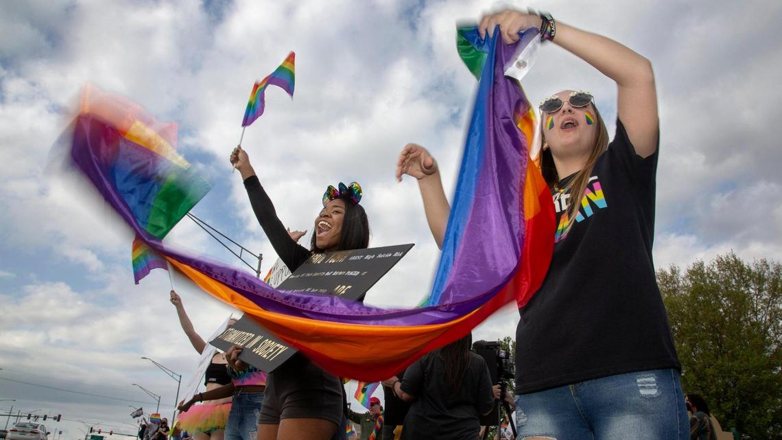 Shuyler Sullivan, right, a 2020 alum of Grain Valley High School and Kenya Butler, a junior, join a crowd of more than 50 people at a rally to support LGBTQ students in the Grain Valley school district Friday, April 29, 2022, in front of Armstrong Park.