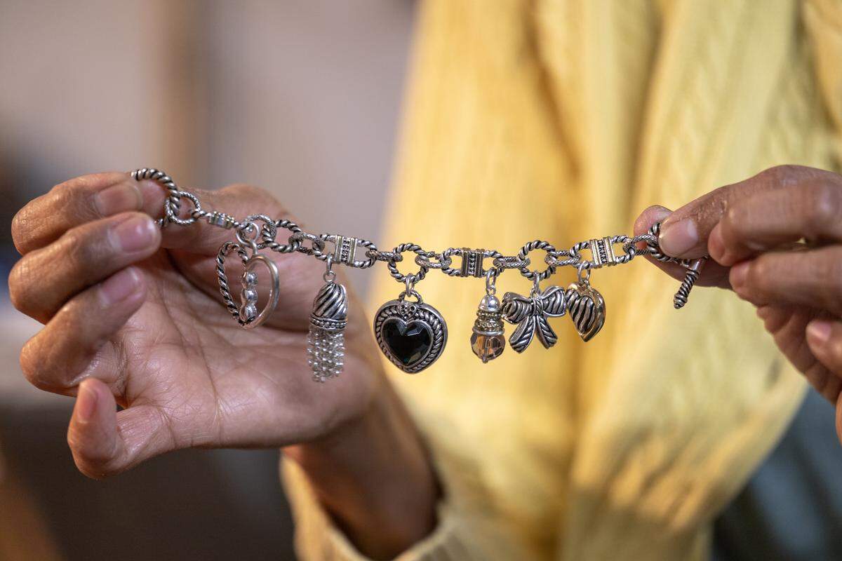 Jo Babaran, a founder/manager of Troost39, a thrift store at 3922 Troost Ave., displays a charm bracelet she priced at $3 on Thursday, Jan. 22 2026, in Kansas City.