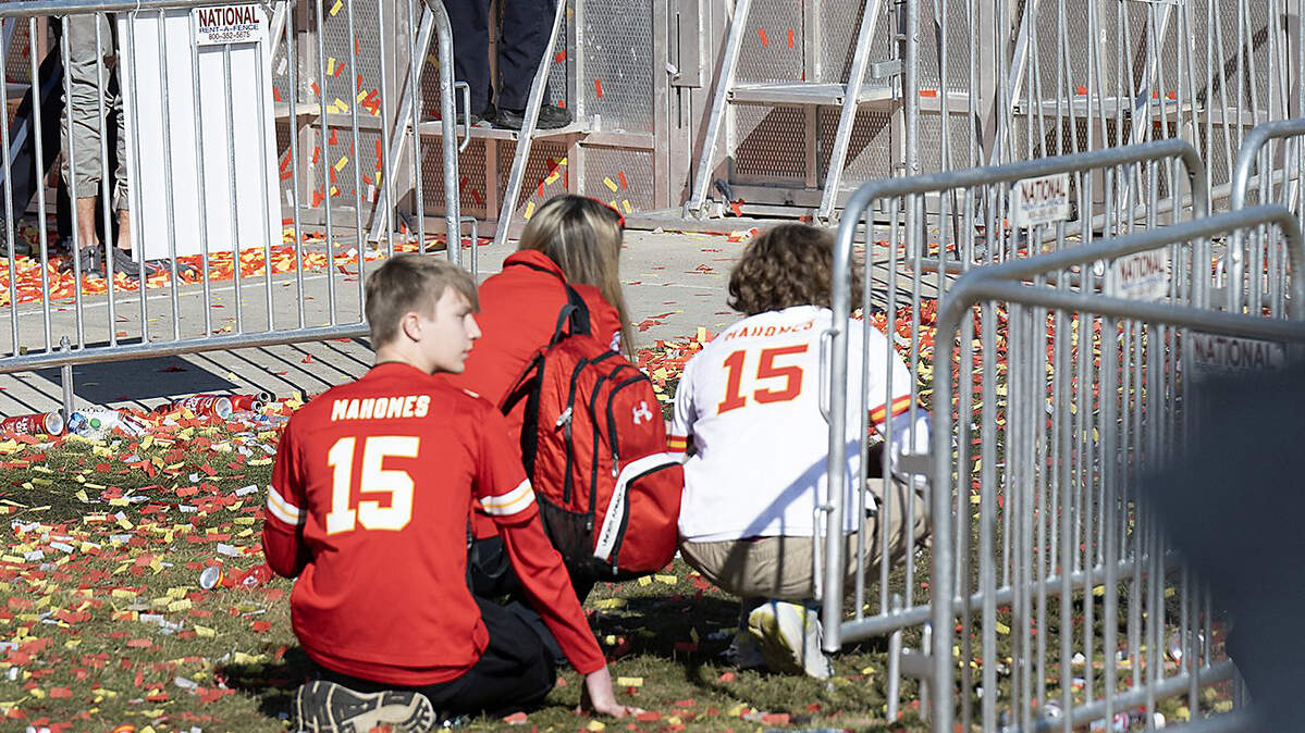 Young Chiefs fans crouch down while several law enforcement officers respond to part of the shooting activity after the Kansas City Chiefs Super Bowl LVIII championship rally on Wednesday at Union Station.