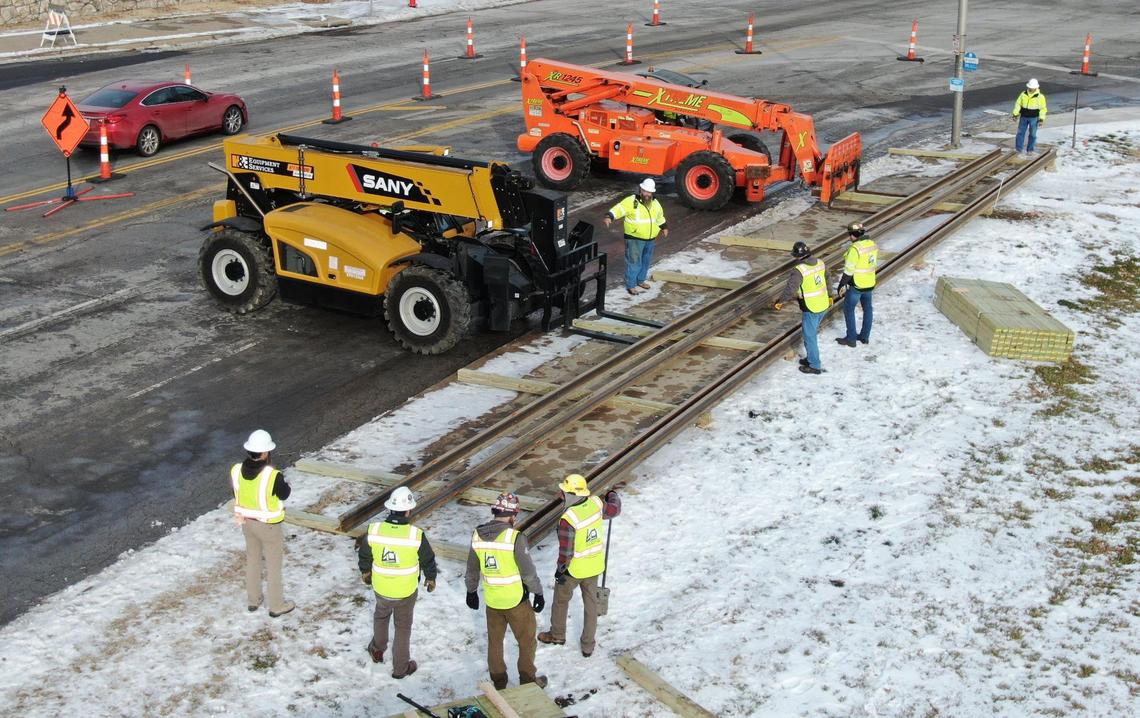 The first delivery of rails for the KC Streetcar Main Street Extension were delivered to the construction site at 27th and Main streets where workers guided the rails onto wood beams as they were unloaded on Tuesday, Jan. 4, 2022, in Kansas City. Over a four-week period, 458 sticks of rails, each 80 feet long and weighing 3,100 pounds, will be delivered for the construction of the streetcar extension which will take about two-and-a-half years.