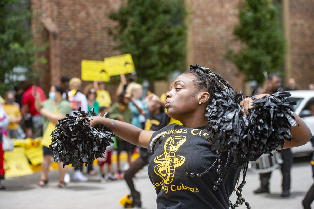 A member of the Kansas City Marching Cobras dances before the a KC Tenants begins outside the Gabriel Tower Apartments in 2021.