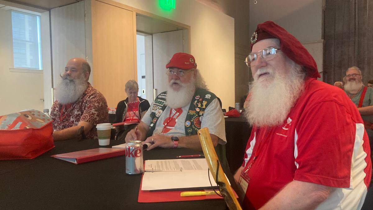 Robert Wade, right, a Santa from Kansas City, sits with other member of Santa America, at a conference at The Hotel Savoy in Downtown Kansas City.