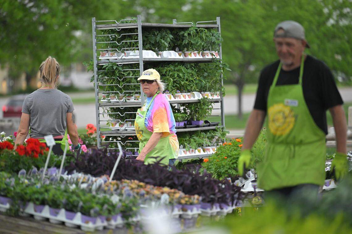 Helen Darrington, center, and her employees, pushed carts of plants into the Kaw Valley greenhouse, set up at Oak Park Mall, to protect them from the storm and the low temperatures expected overnight.