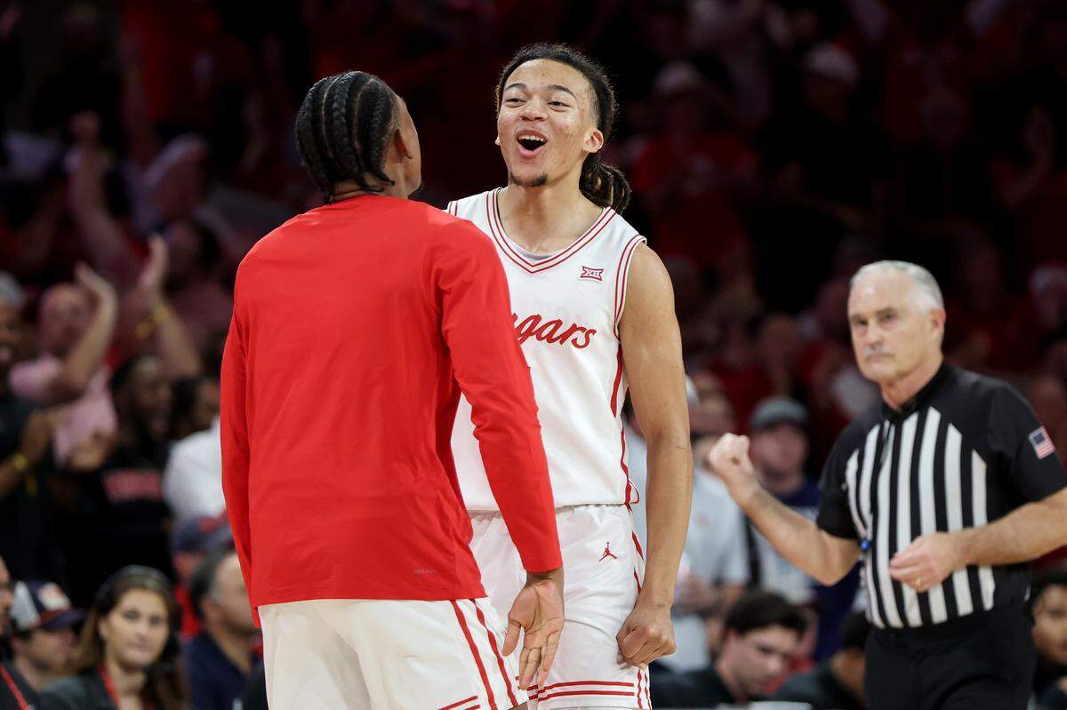 Kingston Flemings #4 of the Houston Cougars is congratulated by Mercy Miller #25 in the second half against the Arizona Wildcats at Fertitta Center on February 21, 2026 in Houston.