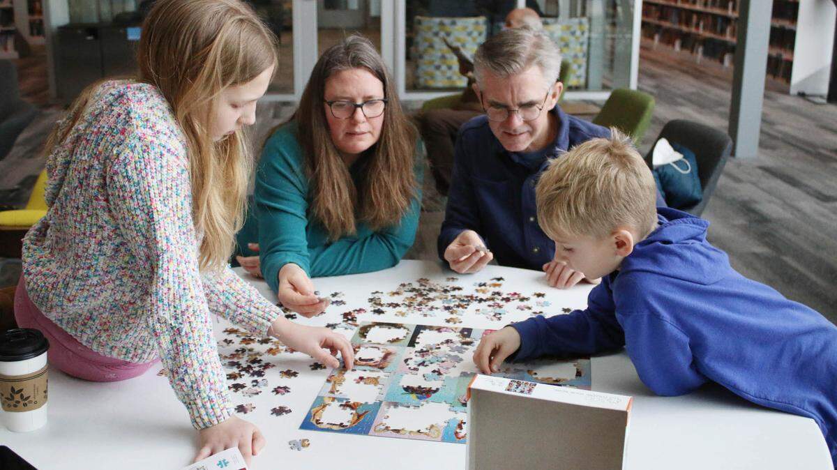 Olathe residents Savanna Paulson, 11, Sonia Paulson, Nathan Paulson and Charlie Paulson, 9, worked together on a puzzle during the competition at Indian Creek Library Feb. 4.